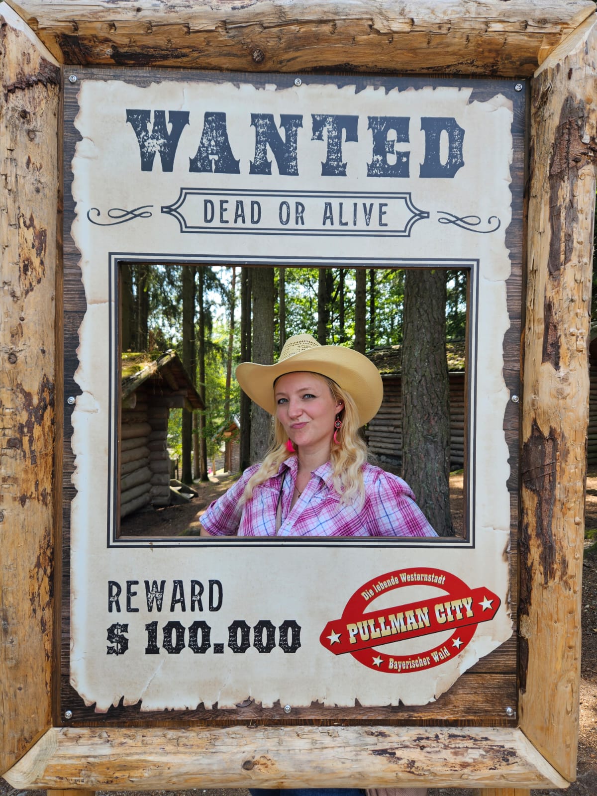 Cowgirl hinterm einem Wanted Schild