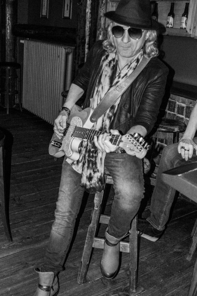 Gitarrist auf Hocker mit Gitarre