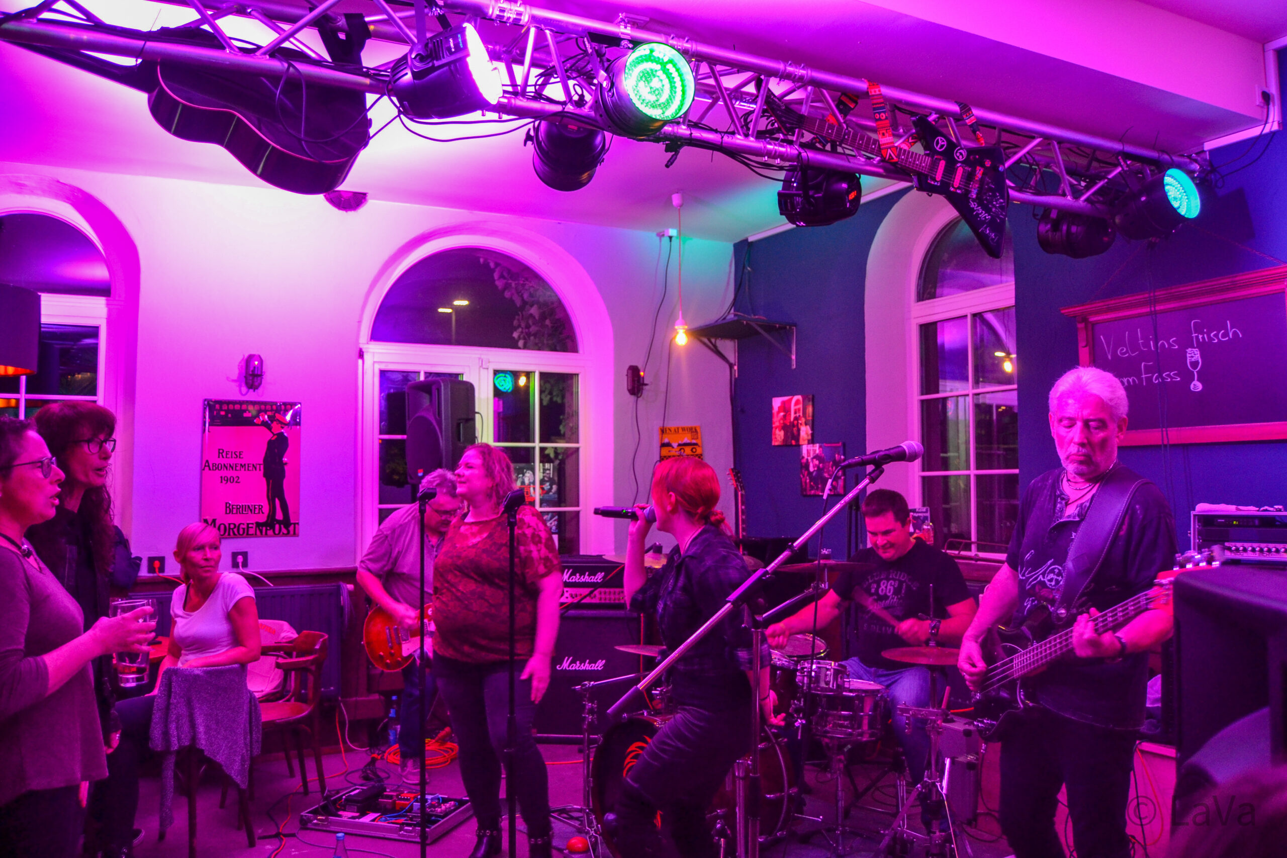 Band bei Konzert mit lila Licht in einer Kneipe