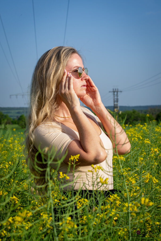 Blonde Frau im Rapsfeld