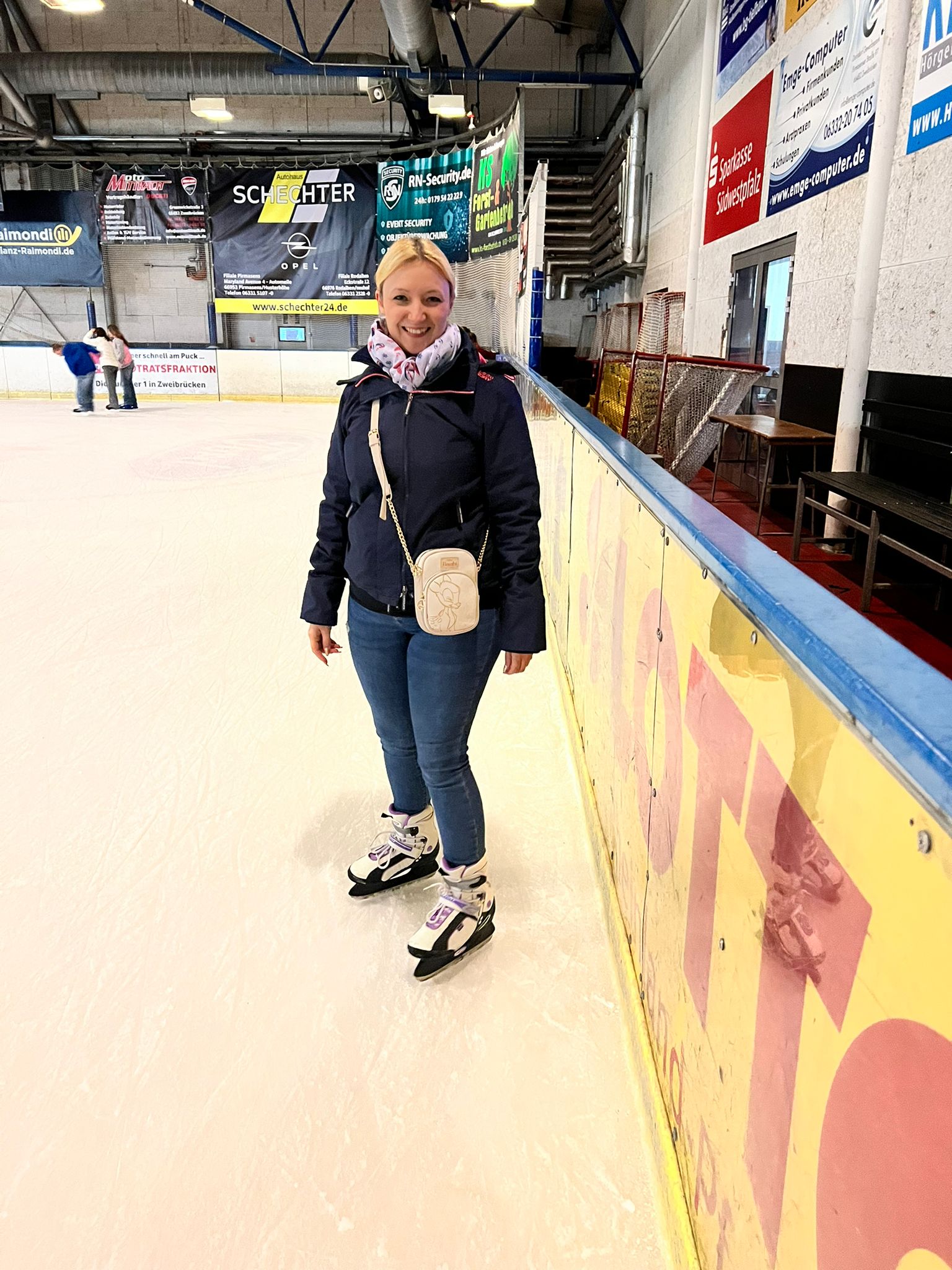 Blonde Frau beim Schlittschuh laufen in der Eishalle