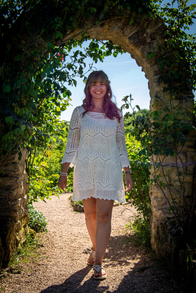 Frau in weißen Kleid im Blumenbogen